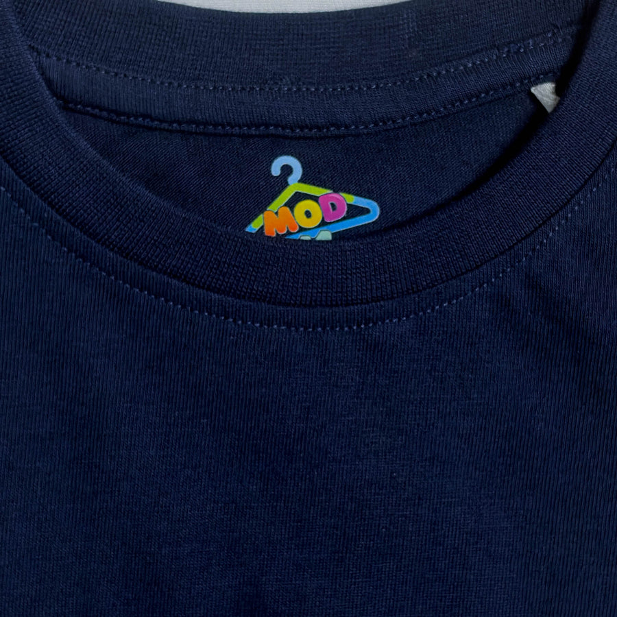 Close-up of a navy blue crewneck t-shirt showing the inner neck label with a colorful embroidered hanger logo that spells 'MOD 11' fabric-closeup