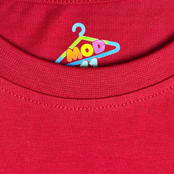 Close-up of a red ribbed knit garment, likely a t-shirt collar, featuring a colorful embroidered logo of a hanger with the letters 'MOD 11' fabric-closeup